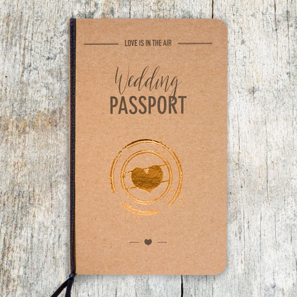 Größere Darstellung Vintage-Hochzeitseinladungen aus braunem Kraftkarton mit goldenem Herz und dunkelbraunem Band am linken Rand. Aufgedruckter Text: Love is in the air und Wedding Passport.
