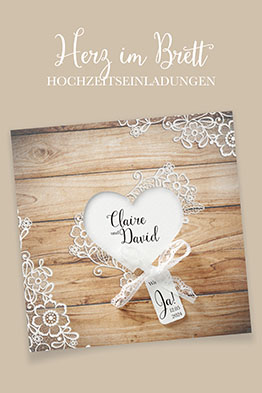 Quadratische Hochzeitseinladung in Holzoptik, in zwei Ecken und in der Mitte mit weißen Spitzenmustern verziert.